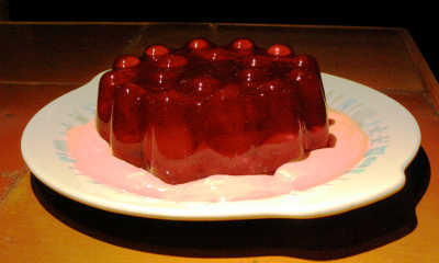 strawberry Jell-O mold in a pool of creamy strawberry stuff